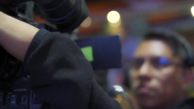 Professional camera operator focusing television camera lens