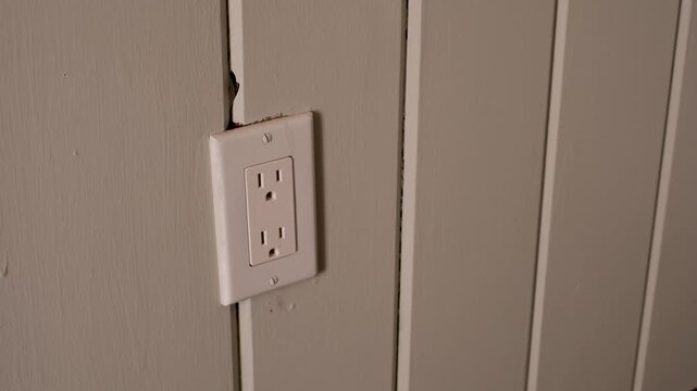 unplugging a blue power adapter from a wall outlet