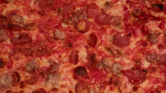 panning shot of a freshly baked meat lovers pizza