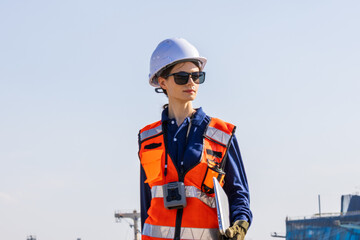Fototapeta premium Female engineer coordinating Energy operations near the coast, supporting Oil/Chemical LPG tanker ship Oversea transport Industry leadership, Oil refinery modernization, and AI-powered monitoring.