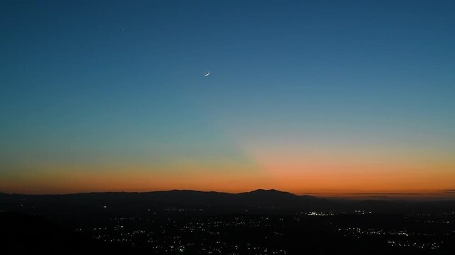 Beautiful nature background featuring wide shot of mountain sunset with moon and Jupiter