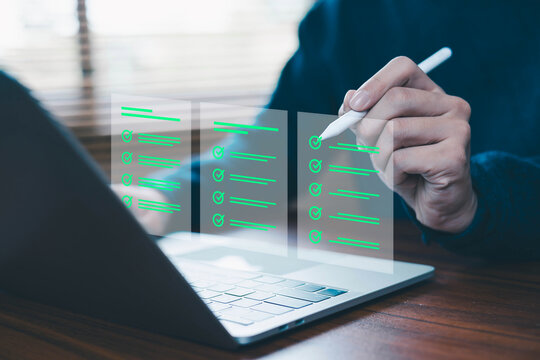 Business professional completing digital checklist on laptop with stylus pen. Concept of task management, compliance audit, quality control, project planning, workflow optimization and productivity.