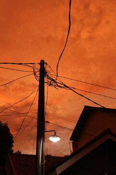 orange sky with clouds and silhouette of house in the neighbourhood