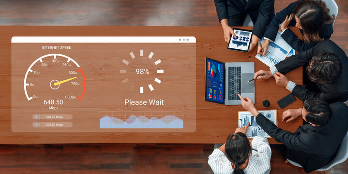 A business meeting in a modern office setting showcasing a digital display of internet speed and a loading animation, highlighting teamwork and technology in action. Ledger