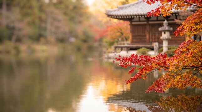 Red and golden japanese maple leaves over a temple pond with stone lantern in autumn, minimal landscape with wide left copy space