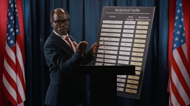 Black politician standing at podium, pointing to reciprocal tariffs chart and gesturing during presentation. Video is ideal for news broadcasts on global trade policies