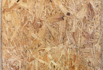 Obraz premium Detailed Texture of Oriented Strand Board for Construction Background. Shot of OSB showing the detailed texture of compressed wooden chips and flakes, ideal for construction or industrial backgrounds.