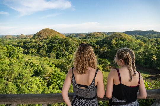 Two women talking while overlooking the Chocolate Hills in the Philippines