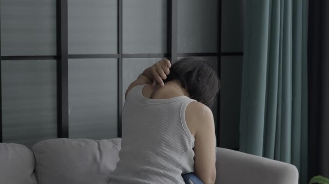 Asian mature woman using gua sha massage her neck