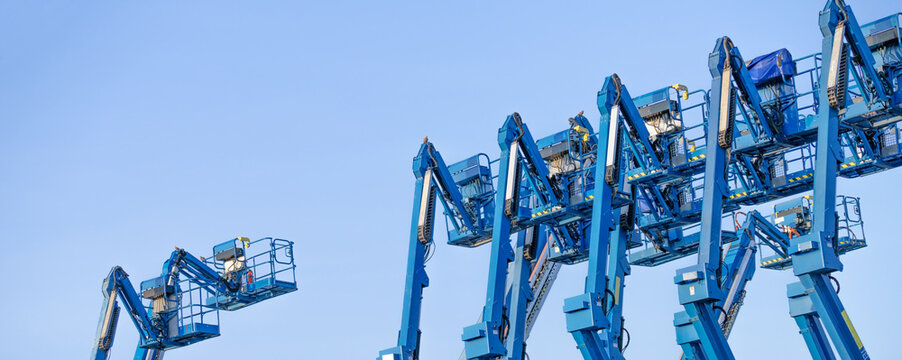 Articulated boom lift. Aerial platform lift. Telescopic boom lift against clear sky. Mobile construction crane for rent and sale. Maintenance and repair hydraulic boom lift service. Crane dealership.