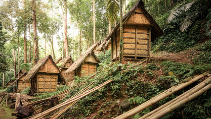 Traditional rice barns surrounded by lush trees in the rural landscape of Baduy Luar Village, Banten, Indonesia © krisbiantography