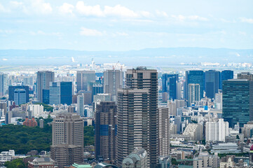 青空の下、東京湾へと広がる高層ビル群の東京都市景観を見渡す眺め © yoshi