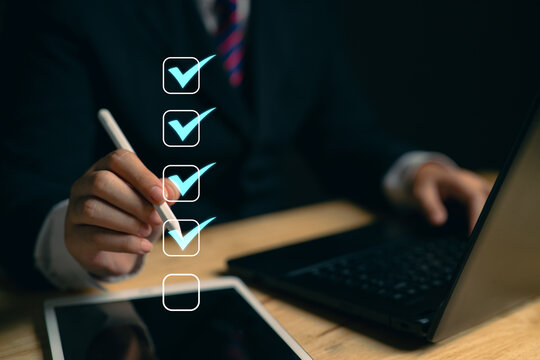 Businessman uses his mouth to check boxes in the document list Concept of online verification form Checklist process sequence The business reviews the job details and ticks the evaluation.