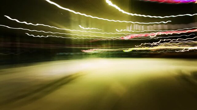 Time-lapse POV of driving on a city highway at night with long exposure light trails for a fast-paced urban transport concept