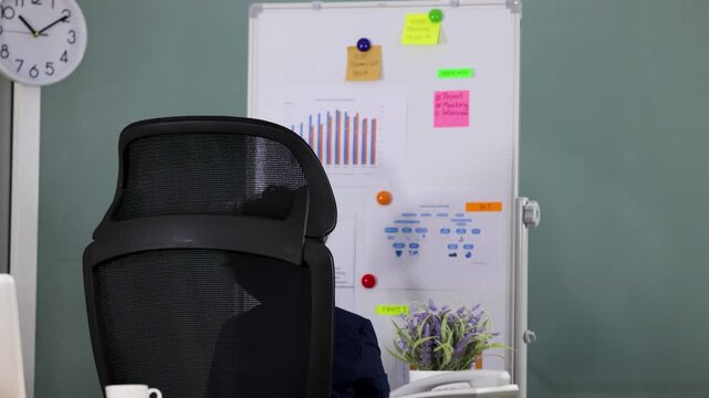 Young Asian Boy in Business Suit Sitting in Office Chair