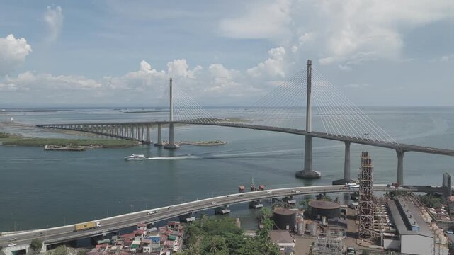 Aerial view of the Cebu-Cordova Link Expressway cable-stayed bridge spanning the Mactan Channel with a boat passing below in Cebu City, Central Visayas, Philippines.