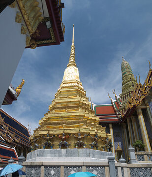 Low angle view of golden Phra Sri Rattana Chedi stupa with Chofa roof edge, Bangkok