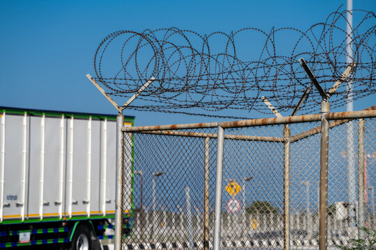 Sharp barbed wire border fence blocking access. Surveillance, conflict, and restricted freedoms, reflecting geopolitical divisions and the impact of immigration policies on displaced people.