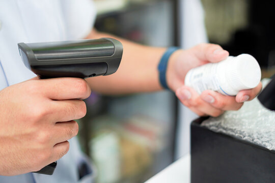Pharmacist Scanning Medication Bottle with Barcode Scanner in Community Pharmacy