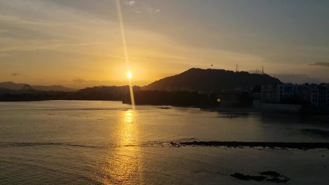 Sunset view from Plaza de Francia in Casco Viejo, Panama City, featuring Cerro Anc&oacute;n with the Panamanian flag and the calm Pacific Ocean glowing in evening light