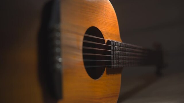 Close-up acoustic guitar body in warm soft light