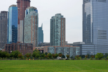 Obraz premium City skyline with glass skyscrapers over a green park