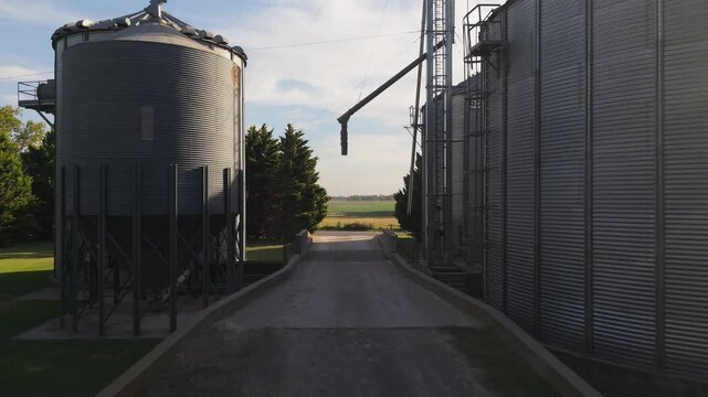 Aerial drone view of large metal grain silos in the middle of the countryside, agricultural storage, farming infrastructure, food production, harvest and agribusiness