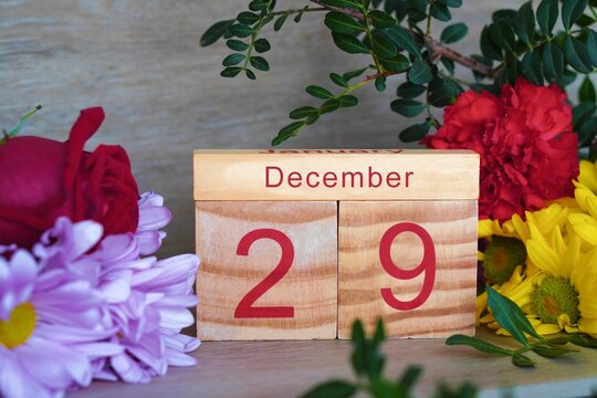 December 29. wooden calendar with fresh flowers around