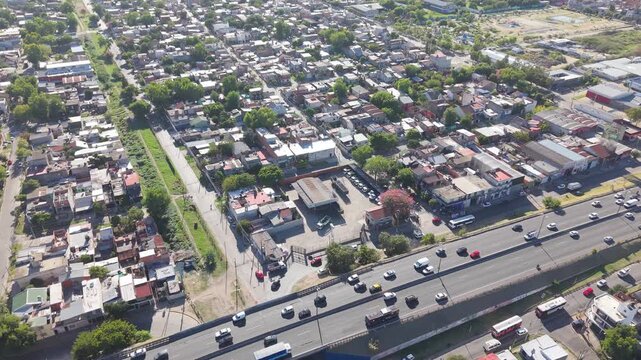 Autopista transitada durante un d&iacute;a soleado en medio de un barrio residencial, movilidad urbana, transporte terrestre, infraestructura vial, conexi&oacute;n metropolitana y vida cotidiana