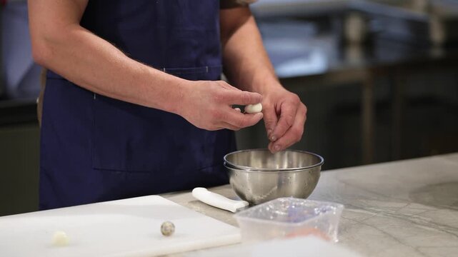 The cook cleans quail eggs with his hands. Very soft focus