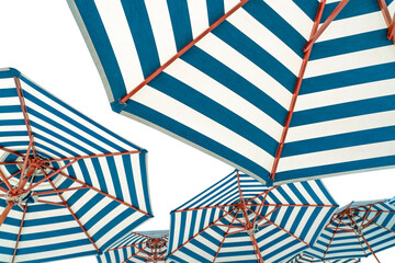 Beach umbrellas isolated on white background. Blue and white striped beach parasol for summer vacation concept. Umbrella for tropical beach in summer. Sunshade for resort decoration. Holiday travel. © Fahroni