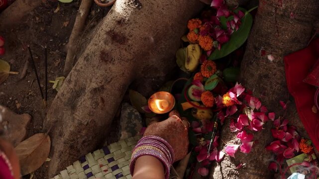 Hindu devotees performing sacred aarti rituals near a banyan tree on the vat Savitri festival