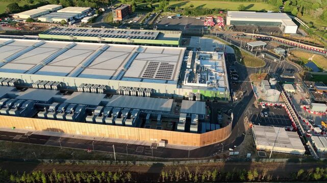 Aerial view of the Google data centre featuring solar panels and cooling systems under bright sunlight in Cheshunt, England, United Kingdom.