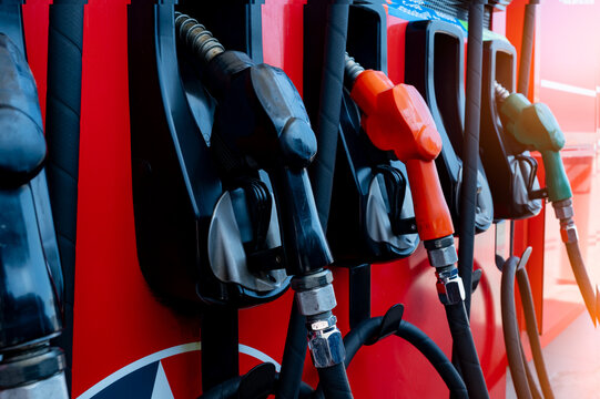 Gas pump nozzle in petrol station. Fuel nozzle in oil dispenser. Fuel dispenser machine. Refueling fill up with petrol gasoline and diesel. Petrol industry and service. Petroleum oil consumption.