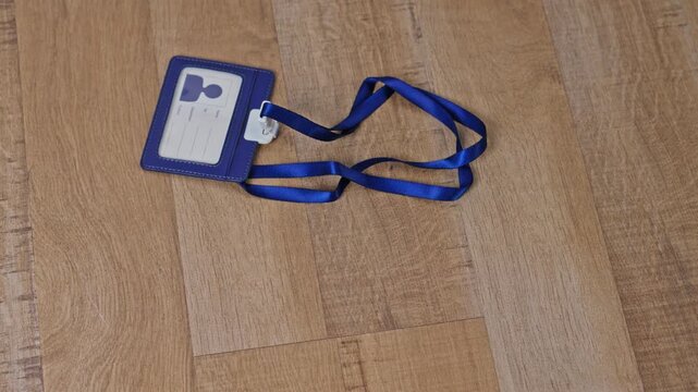 Corporate staff pass template falling down on wooden surface for Concept of losing job