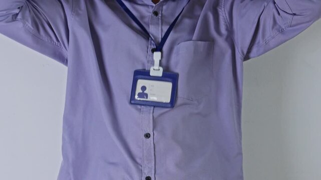 Close-up of Office employee wearing shirt putting on blank corporate identification pass