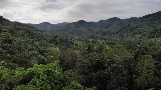 Aerial drone footage of a calm mountains and clouds. Ideal for nature, travel, environment, tropical forest, and cinematic landscape projects.