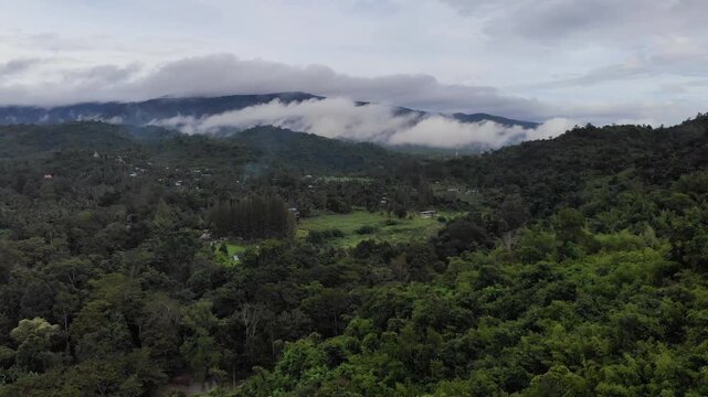 Aerial drone footage of a calm mountains and clouds. Ideal for nature, travel, environment, tropical forest, and cinematic landscape projects.