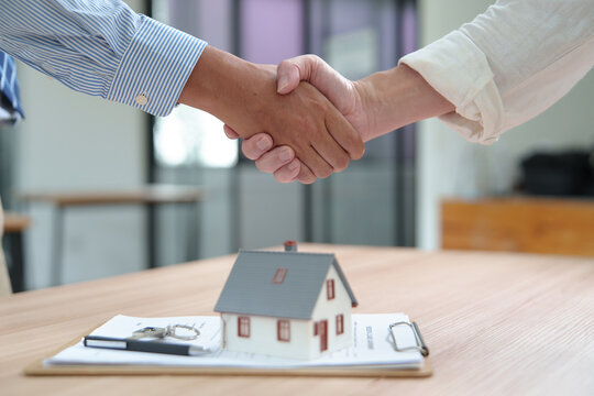 Business Handshake Over Home Purchase Agreement in Real Estate T