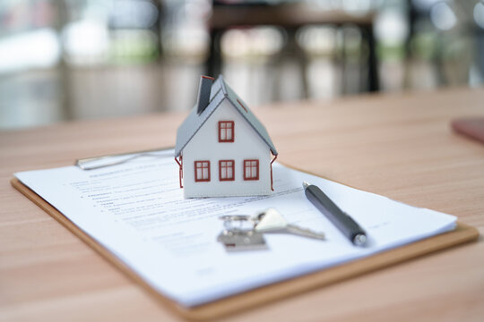 Real Estate Concept with House Model and Keys on Property Docume