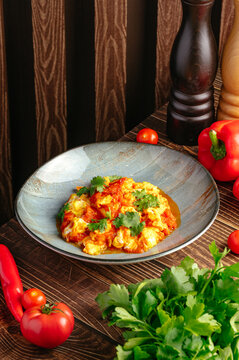 Rustic plate of scrambled eggs with fresh tomatoes