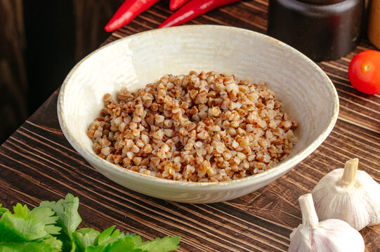 Bowl of cooked buckwheat with fresh vegetables and garlic