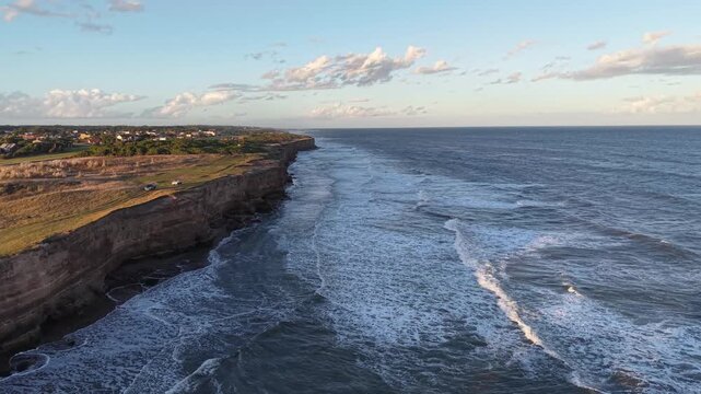 Costa rocosa con olas rompiendo contra acantilados al atardecer. Paisaje marino, costa atl&aacute;ntica, ciudad balnearia, naturaleza, vacaciones, relajaci&oacute;n, turismo, hora dorada, mar, Chapadmalal, Buenos A