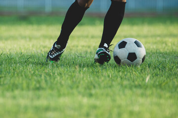 Fototapeta premium Close-Up of Soccer Player Dribbling Ball on Green Grass Field in Stadium
