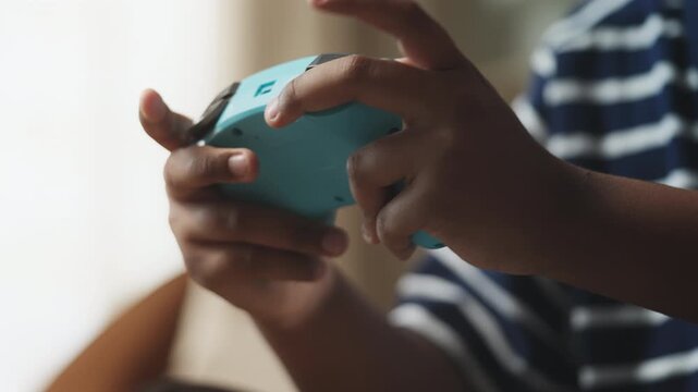 African American boy playing a video game and pressing buttons on a controller