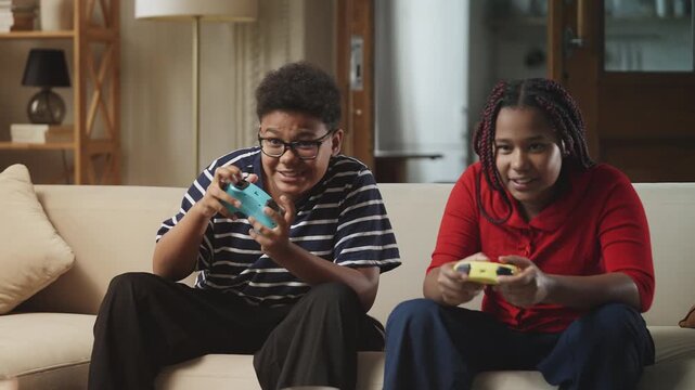 African American siblings giving each other a high five to celebrate a game win