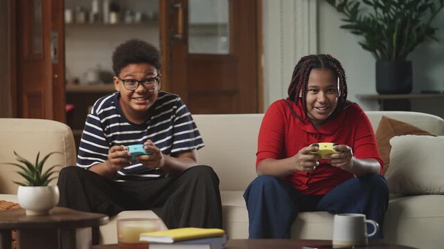 Cheerful children celebrating a video game win with their signature handshake