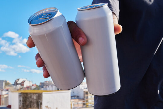 Hands holding two white cans