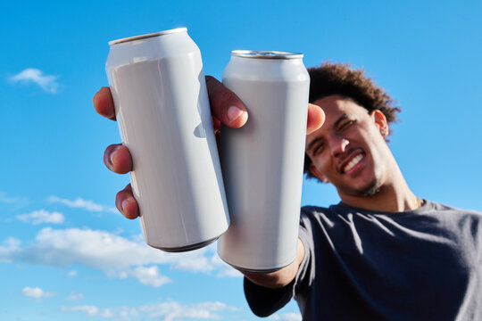 Man holding two white cans