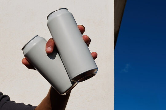 Hands holding two cans
